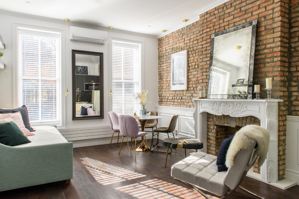 Inspiration for a transitional living room in New York with white walls, dark hardwood floors, a standard fireplace, a brick fireplace surround, brown floor and brick walls.