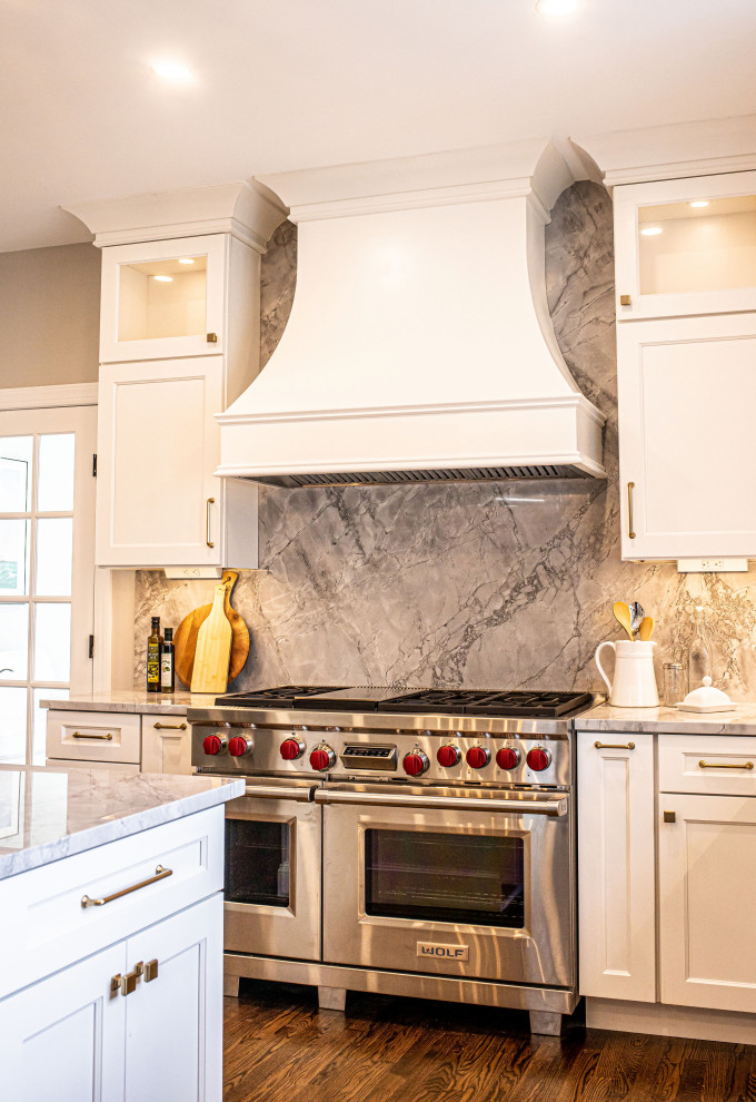 Large transitional dark wood floor and brown floor eat-in kitchen photo in Baltimore with an undermount sink, shaker cabinets, white cabinets, marble countertops, white backsplash, marble backsplash, stainless steel appliances, an island and gray countertops
