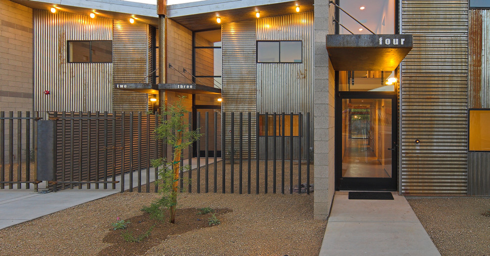 Mid-sized modern front door in Phoenix with metallic walls, concrete floors, a single front door and a black front door.