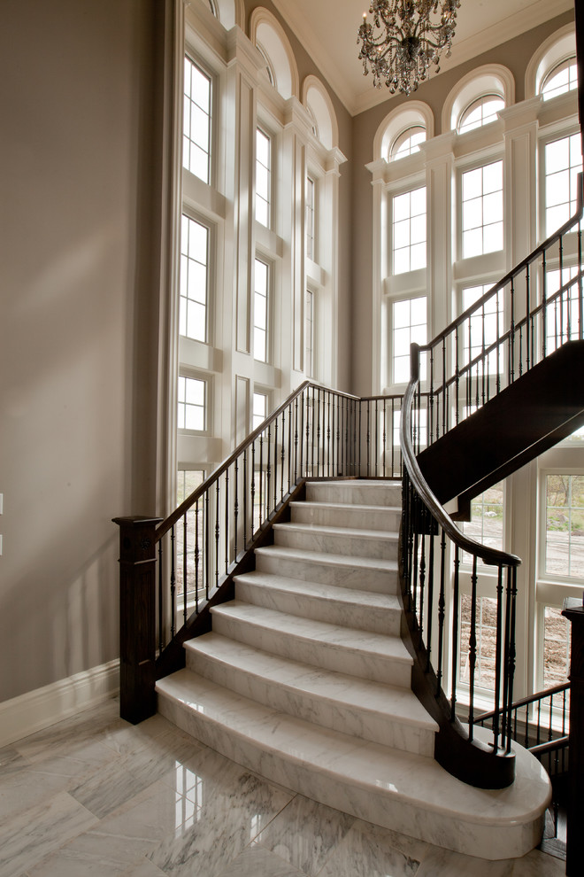 Photo of an expansive traditional marble l-shaped staircase in Toronto with marble risers.