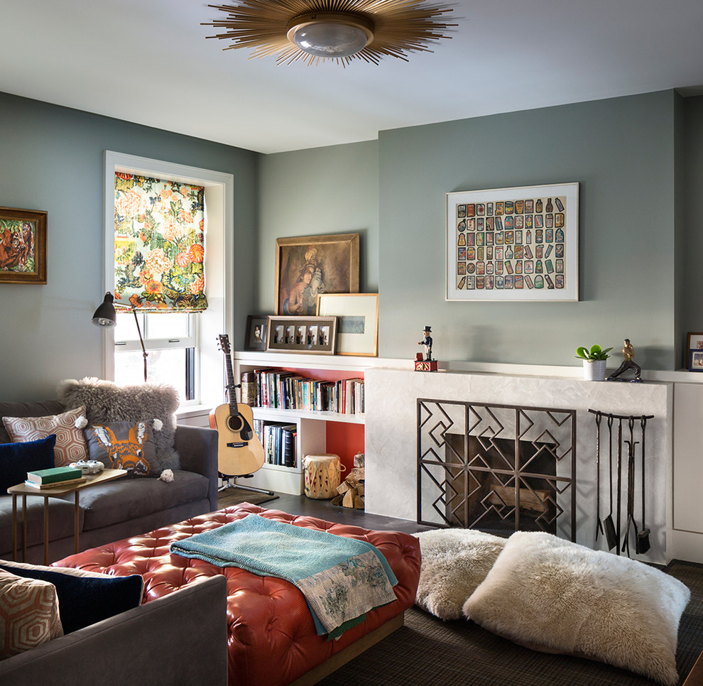 Photo of a transitional living room in New York with a standard fireplace, a library and grey walls.