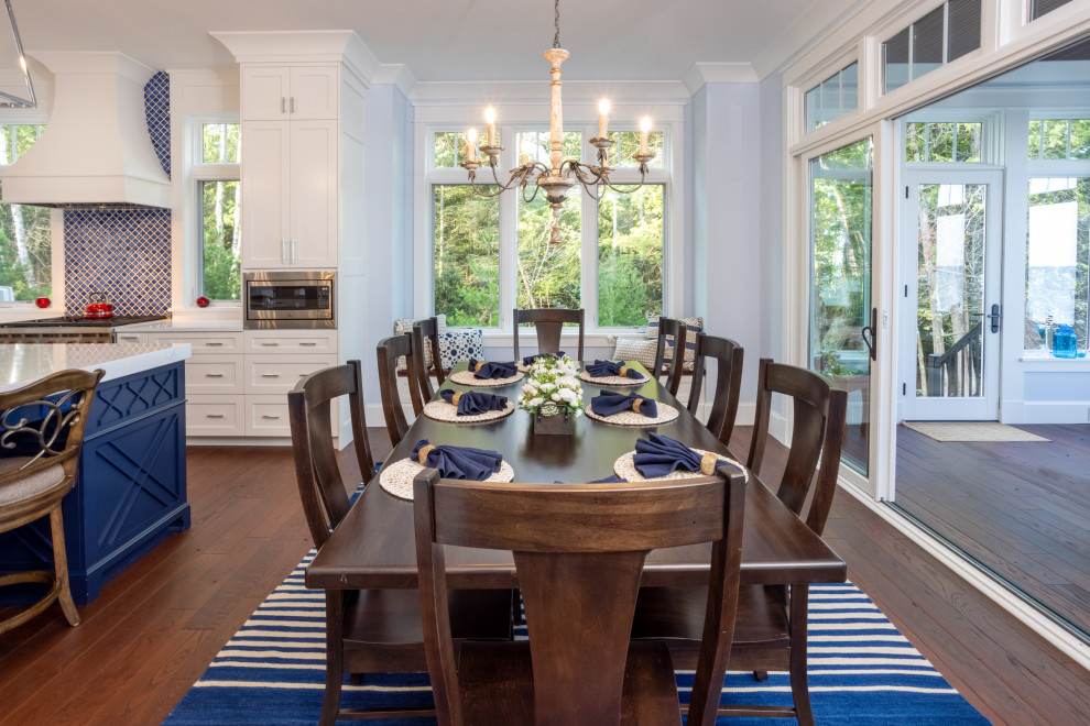 Exemple d'une salle à manger ouverte sur la cuisine chic de taille moyenne avec un mur bleu, parquet foncé et un sol marron.