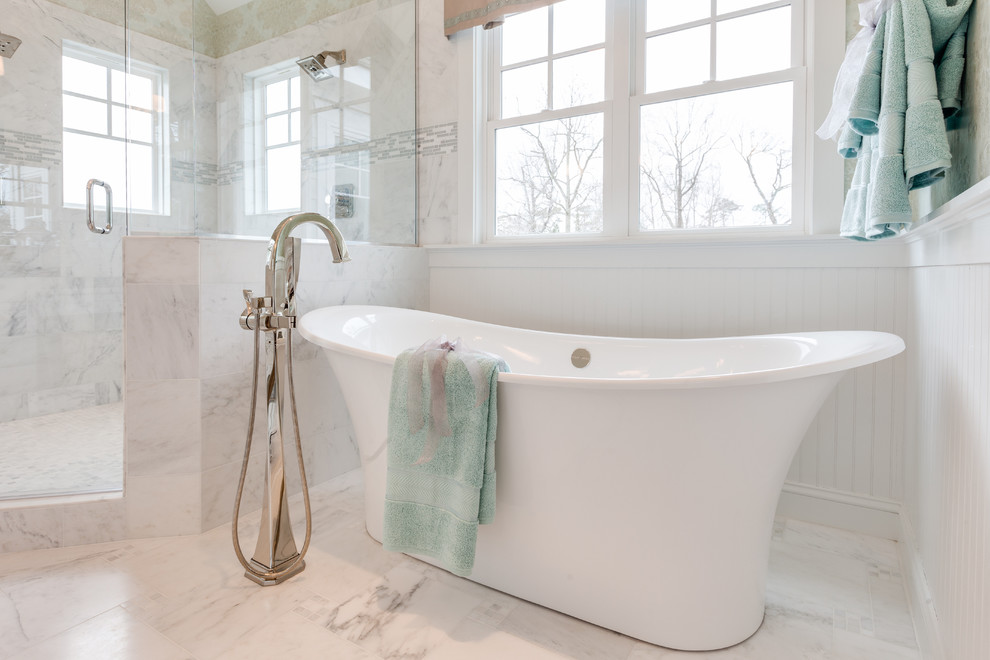 Photo of a large beach style master bathroom in Other with an undermount sink, recessed-panel cabinets, white cabinets, marble benchtops, a freestanding tub, a corner shower, a two-piece toilet, white tile, stone tile, blue walls and marble floors.