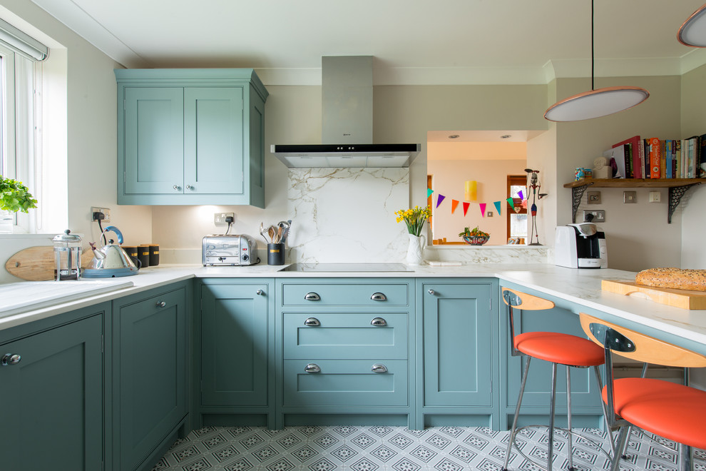Photo of a transitional u-shaped separate kitchen in Kent with a drop-in sink, shaker cabinets, blue cabinets, white splashback, a peninsula and multi-coloured floor.