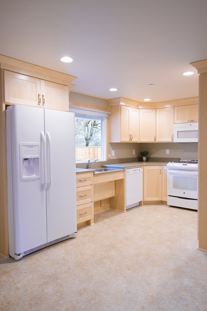 This is an example of a mid-sized transitional u-shaped separate kitchen in Portland with an undermount sink, shaker cabinets, light wood cabinets, quartz benchtops, white appliances, vinyl floors, no island, multi-coloured floor and grey benchtop.