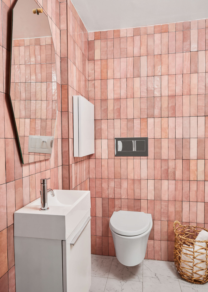 This is an example of a small contemporary powder room in Toronto with white cabinets, a wall-mount toilet, pink tile, pink walls, porcelain floors, white floor and a floating vanity.