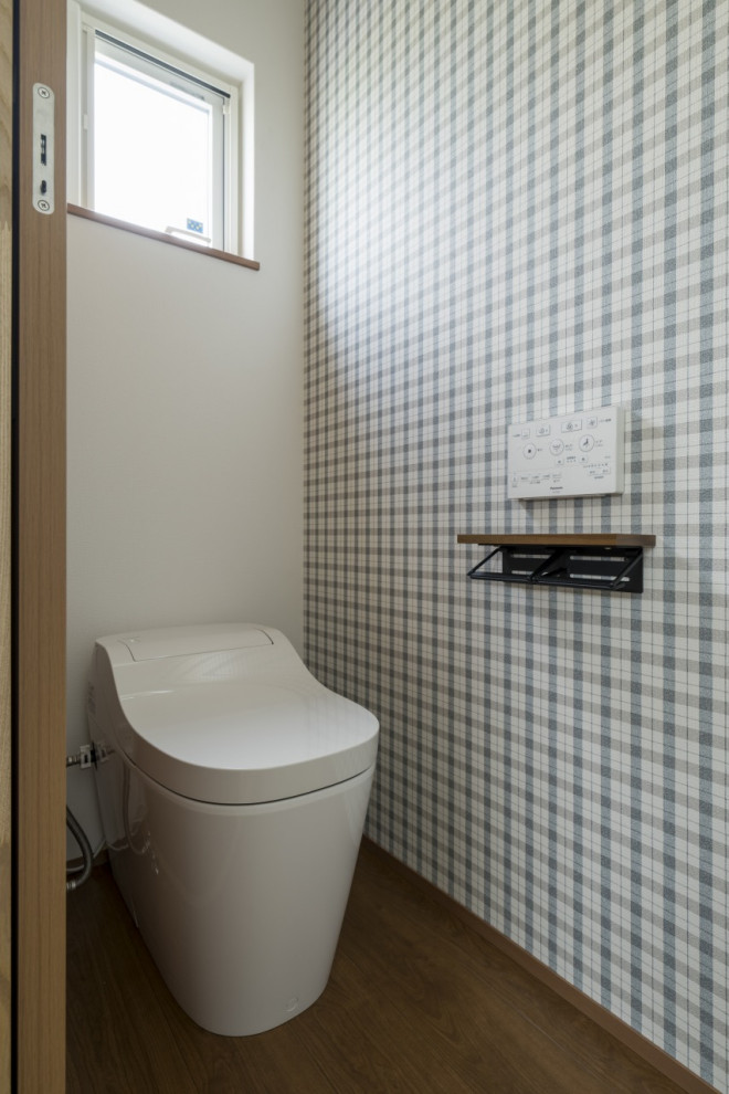 Idées déco pour un WC et toilettes moderne de taille moyenne avec un bidet, parquet clair, un sol marron, un plafond en papier peint et du papier peint.
