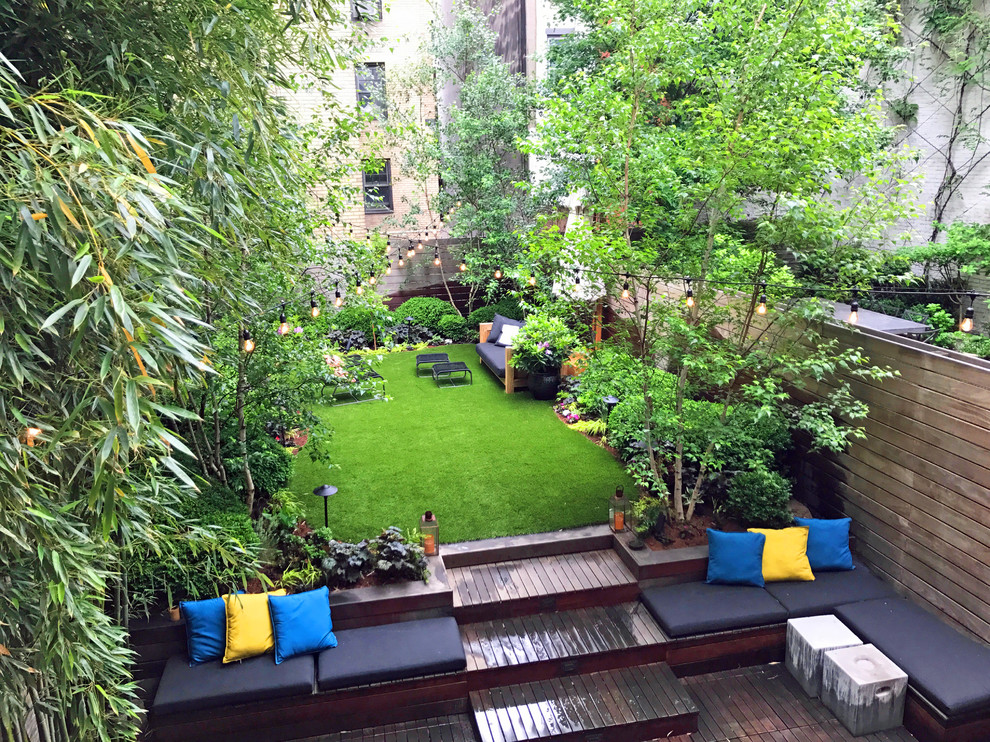 Eclectic backyard partial sun garden in New York with decking for spring.