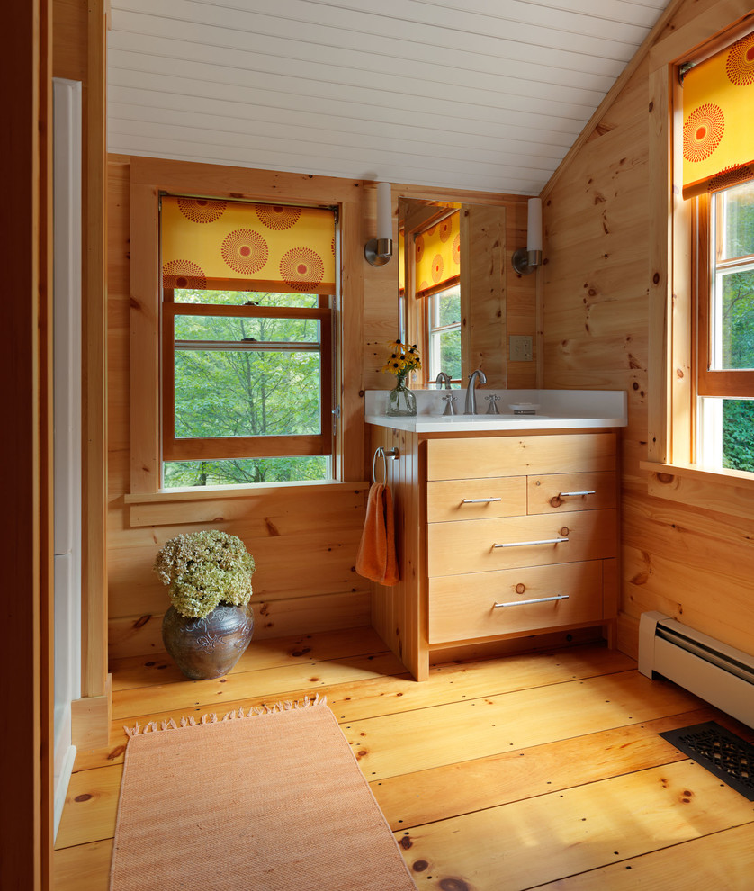 This is an example of a country bathroom in Burlington with flat-panel cabinets, light wood cabinets and light hardwood floors.
