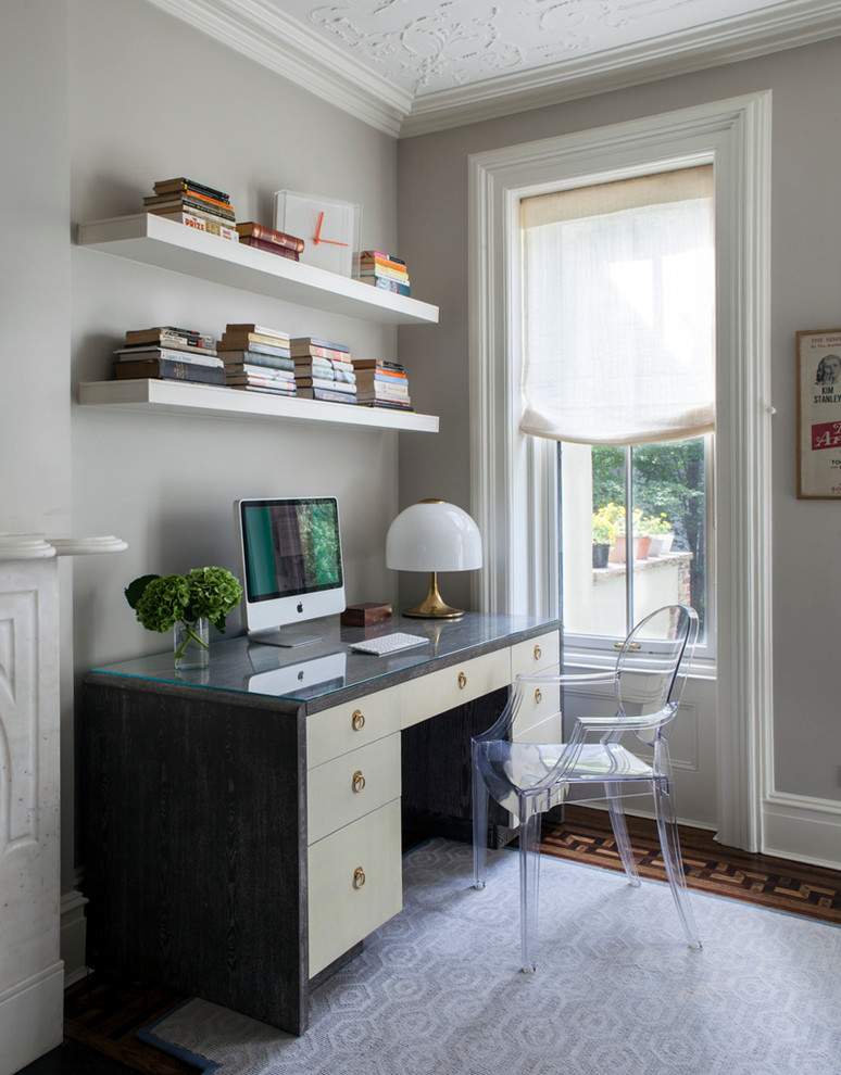 Transitional home office in New York with grey walls, dark hardwood floors and a freestanding desk.