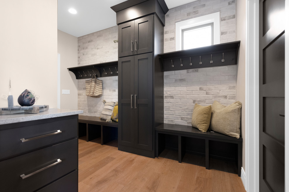 Inspiration for a medium sized modern boot room in Other with grey walls, light hardwood flooring, brown floors and brick walls.