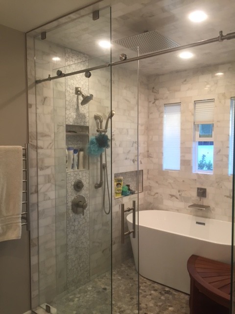 Photo of a mid-sized midcentury master bathroom in San Francisco with raised-panel cabinets, white cabinets, a claw-foot tub, an alcove shower, a one-piece toilet, white tile, matchstick tile, white walls, light hardwood floors, an integrated sink and granite benchtops.