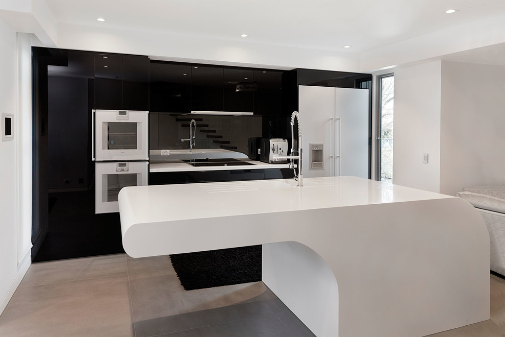 Design ideas for a mid-sized contemporary galley eat-in kitchen in Melbourne with flat-panel cabinets, black splashback, glass sheet splashback, stainless steel appliances, concrete floors and with island.