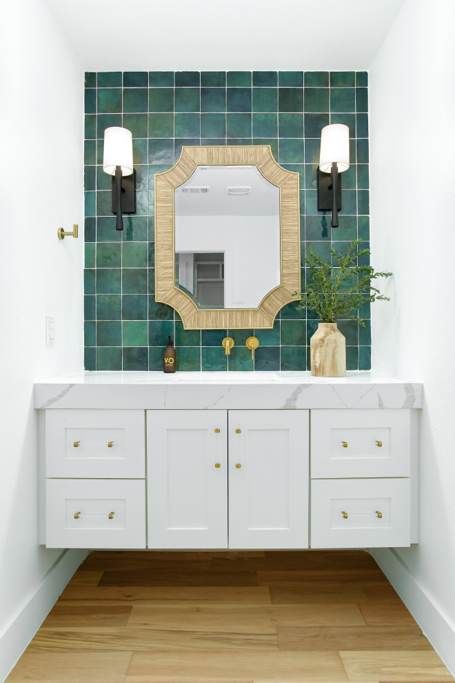 Transitional powder room in Dallas with shaker cabinets, white cabinets, green tile, white walls, medium hardwood floors, an undermount sink, brown floor, white benchtops and a floating vanity.