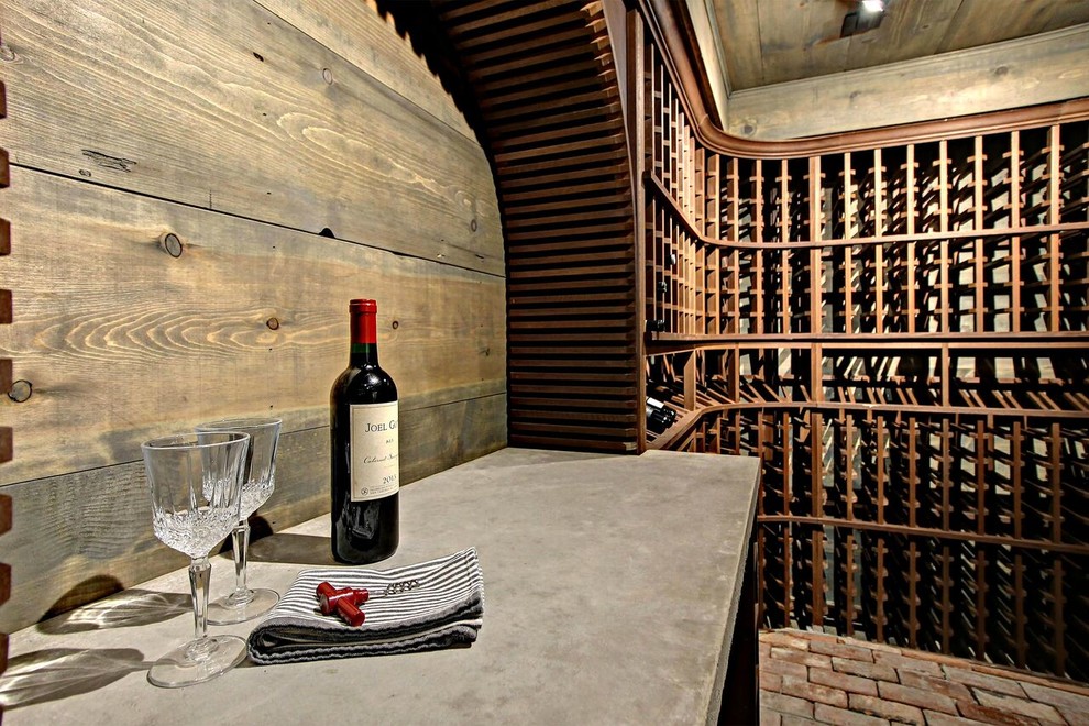 Cette image montre une cave à vin traditionnelle avec un sol en brique et un présentoir.