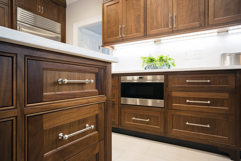 Large traditional u-shaped eat-in kitchen in Richmond with an undermount sink, beaded inset cabinets, dark wood cabinets, marble benchtops, white splashback, porcelain splashback, stainless steel appliances, porcelain floors and with island.