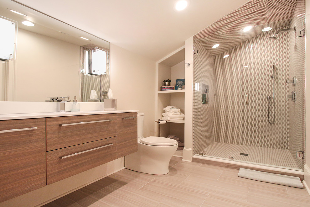 Design ideas for a small transitional kids bathroom in New Orleans with flat-panel cabinets, light wood cabinets, an alcove shower, a two-piece toilet, gray tile, pebble tile, white walls, porcelain floors, an undermount sink, engineered quartz benchtops, grey floor, a hinged shower door and white benchtops.