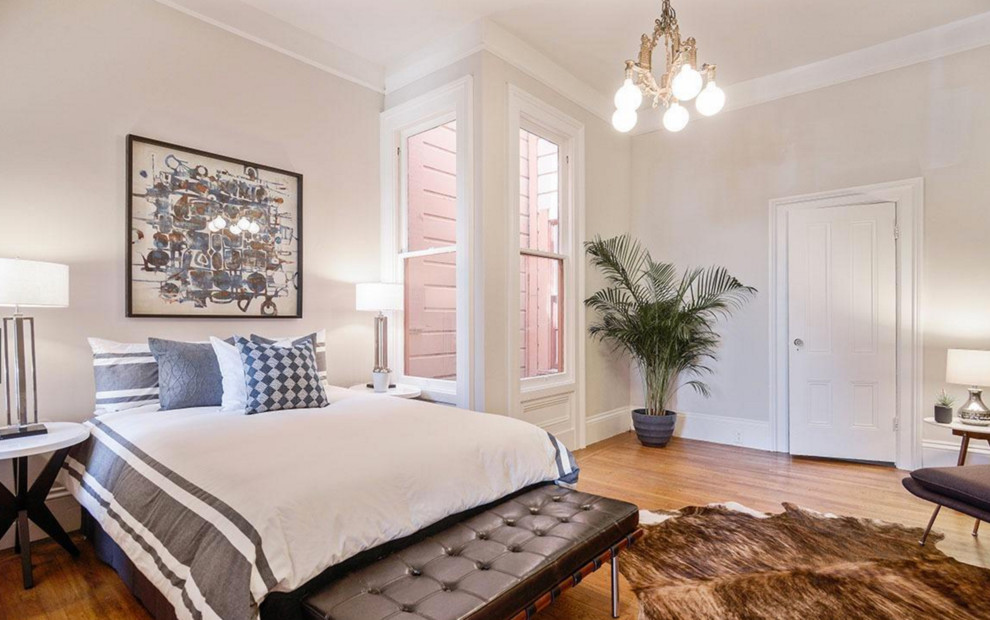 Inspiration for a large transitional bedroom in Manchester with grey walls and medium hardwood floors.
