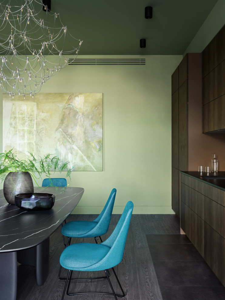 На фото: большая кухня-столовая в современном стиле с зелеными стенами, темным паркетным полом и коричневым полом