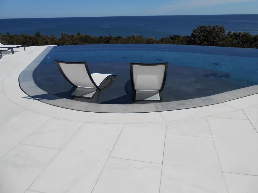 Large backyard stone and custom-shaped pool photo in New York
