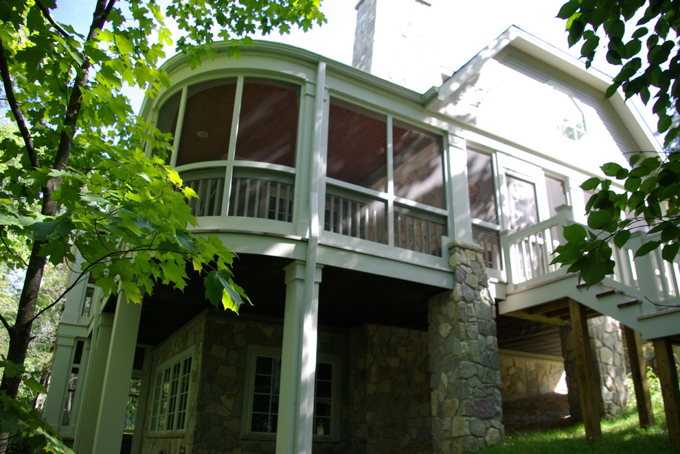 Photo of a mid-sized traditional backyard screened-in verandah in Milwaukee with a roof extension.