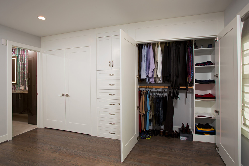 Large contemporary gender-neutral built-in wardrobe in DC Metro with recessed-panel cabinets, white cabinets and dark hardwood floors.