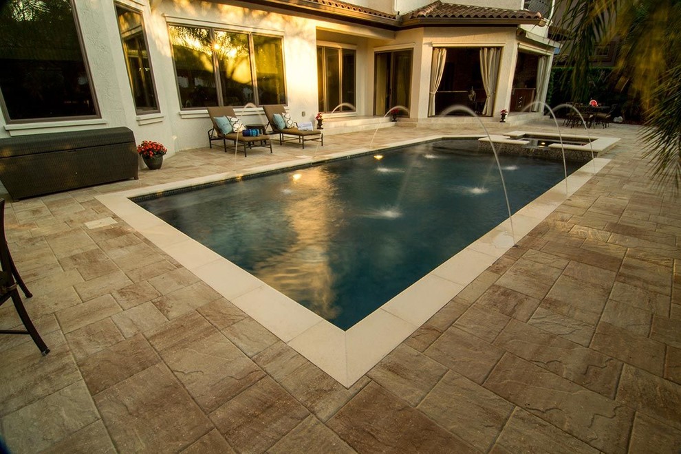 Inspiration for a mid-sized mediterranean backyard custom-shaped pool in Jacksonville with a water feature and concrete pavers.