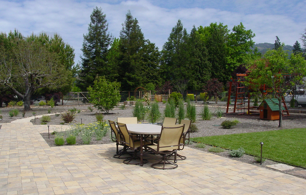This is an example of a large contemporary backyard patio in Other with concrete pavers.