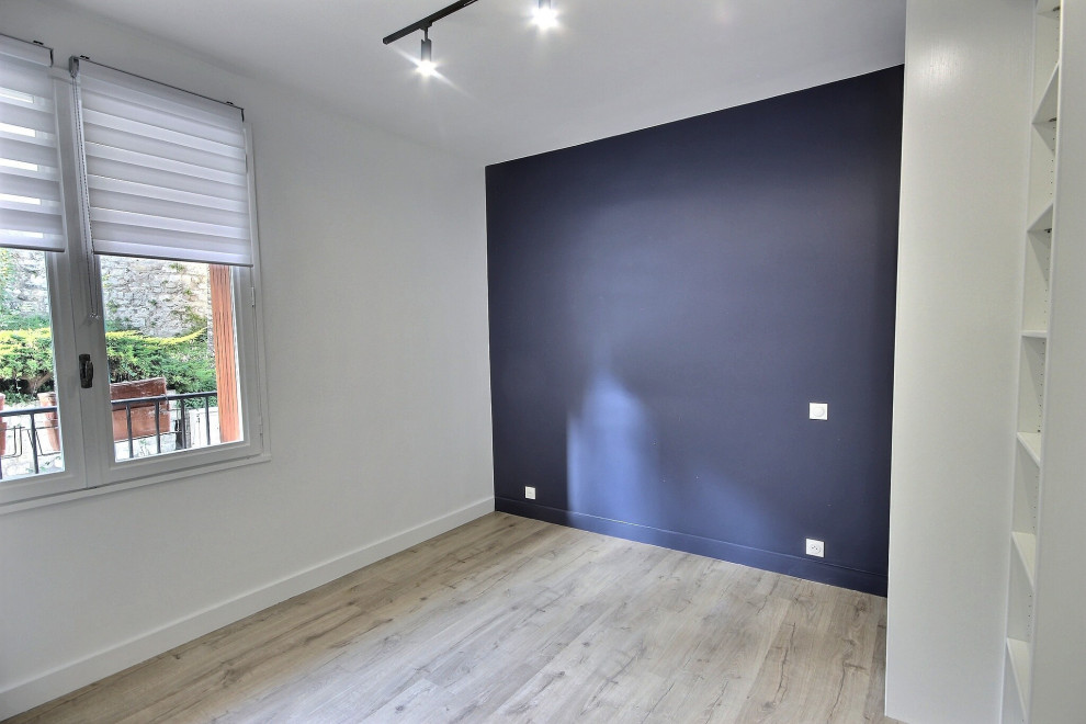 Exempel på ett litet modernt könsneutralt tonårsrum kombinerat med sovrum, med blå väggar, laminatgolv och grått golv