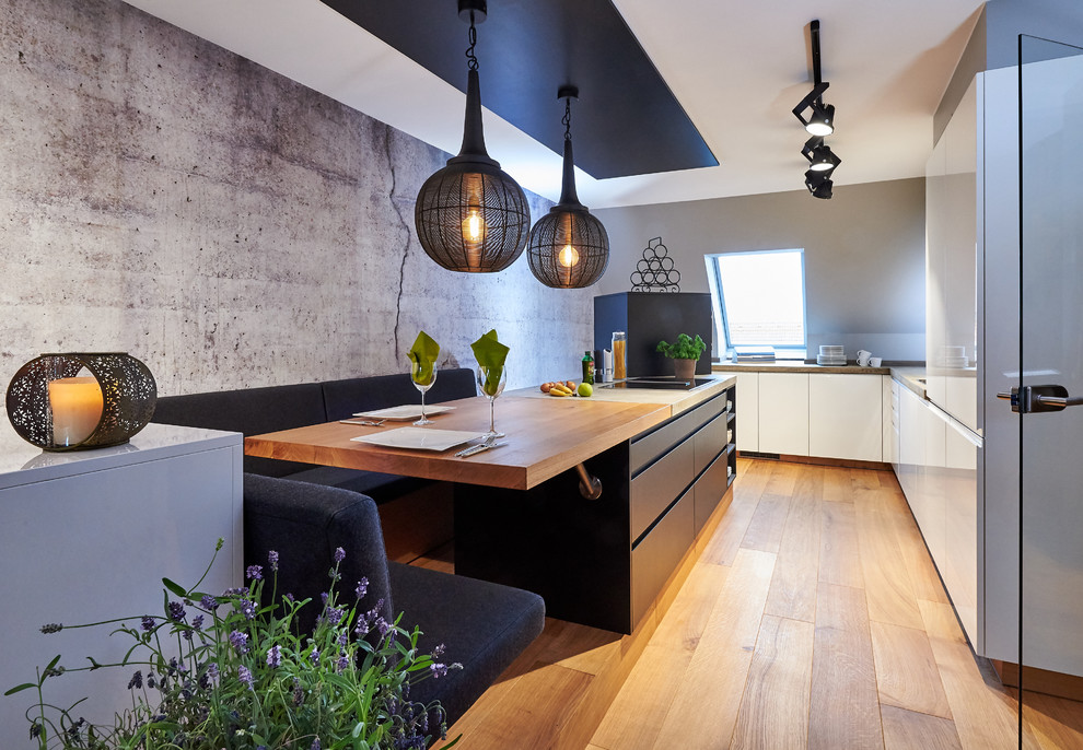 Design ideas for an expansive contemporary l-shaped kitchen in Munich with flat-panel cabinets, concrete benchtops, with island, grey benchtop, white cabinets and light hardwood floors.