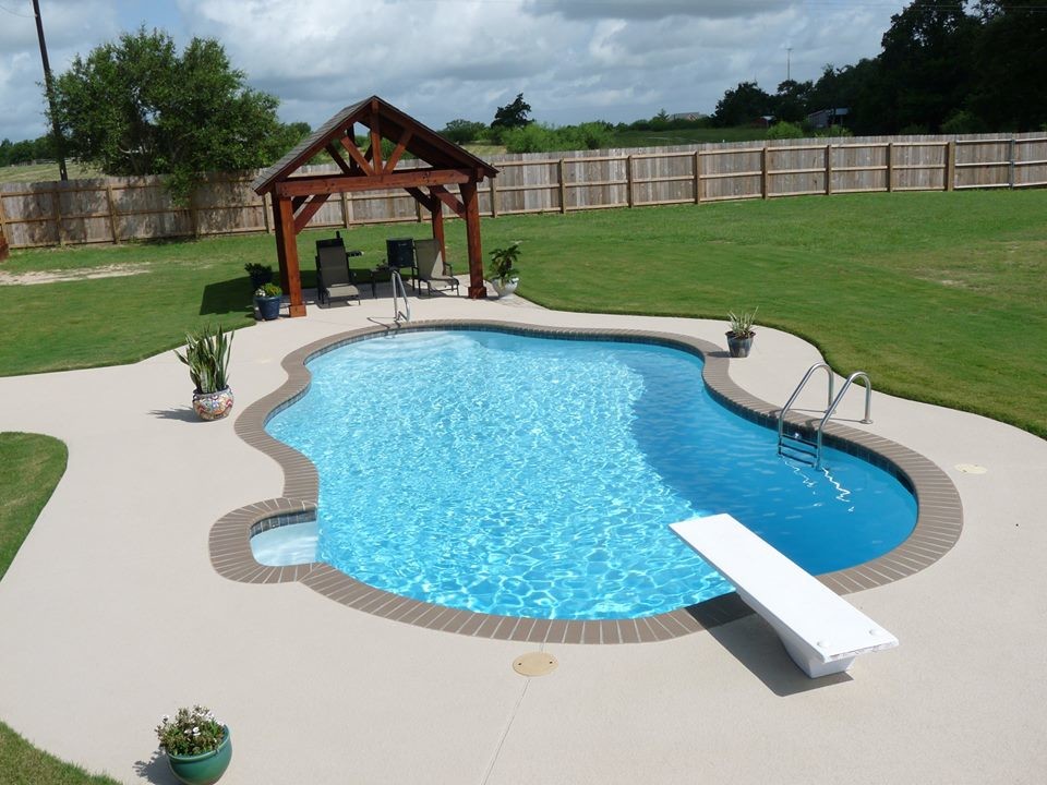 Photo of a large traditional backyard custom-shaped lap pool in Houston with decomposed granite.