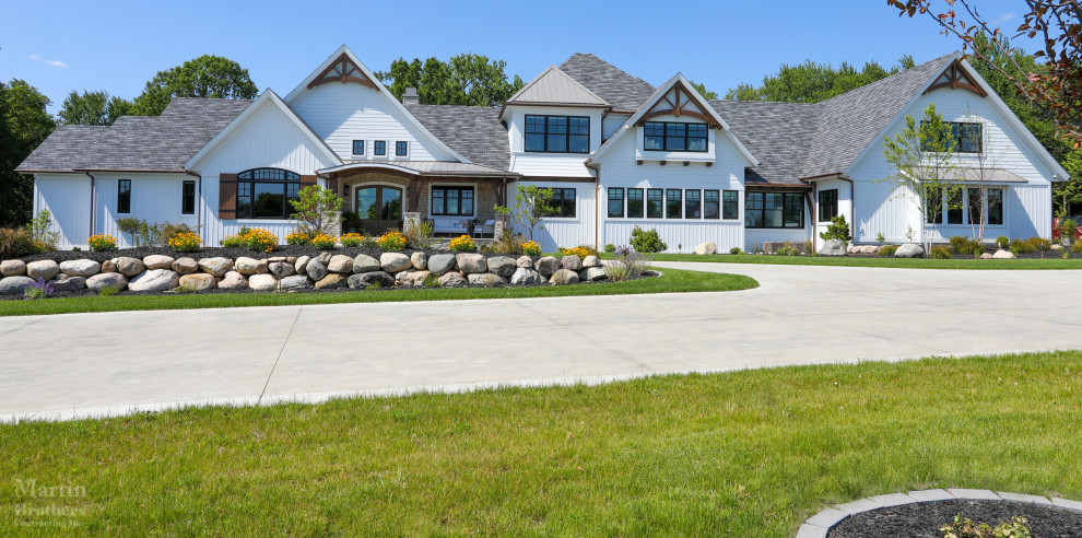 Modern Farmhouse - Front elevation featuring cedar gable brackets, Celect Board & Batten and D7 Shake siding in white; Boral trim boards; cedar lined ceilings; cedar brackets; copper gutters and downspouts; metal roofs and GAF Slateline English Gray Slate roofing shingles. Buechel Stone Fond du Lac Cambrian Blend stone on porch front and posts. Landscaping by Linton's Enchanted Gardens.

General contracting by Martin Bros. Contracting, Inc.; Architecture by Helman Sechrist Architecture; Home Design by Maple & White Design; Photography by Marie Kinney Photography.

Images are the property of Martin Bros. Contracting, Inc. and may not be used without written permission.