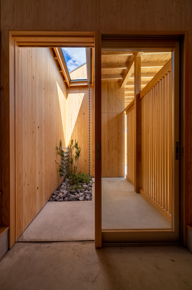 Источник вдохновения для домашнего уюта: входная дверь среднего размера в стиле модернизм с бежевыми стенами, бетонным полом, раздвижной входной дверью, входной дверью из светлого дерева, серым полом, деревянным потолком и деревянными стенами