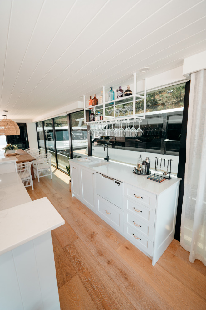 Beach style home bar in Other.