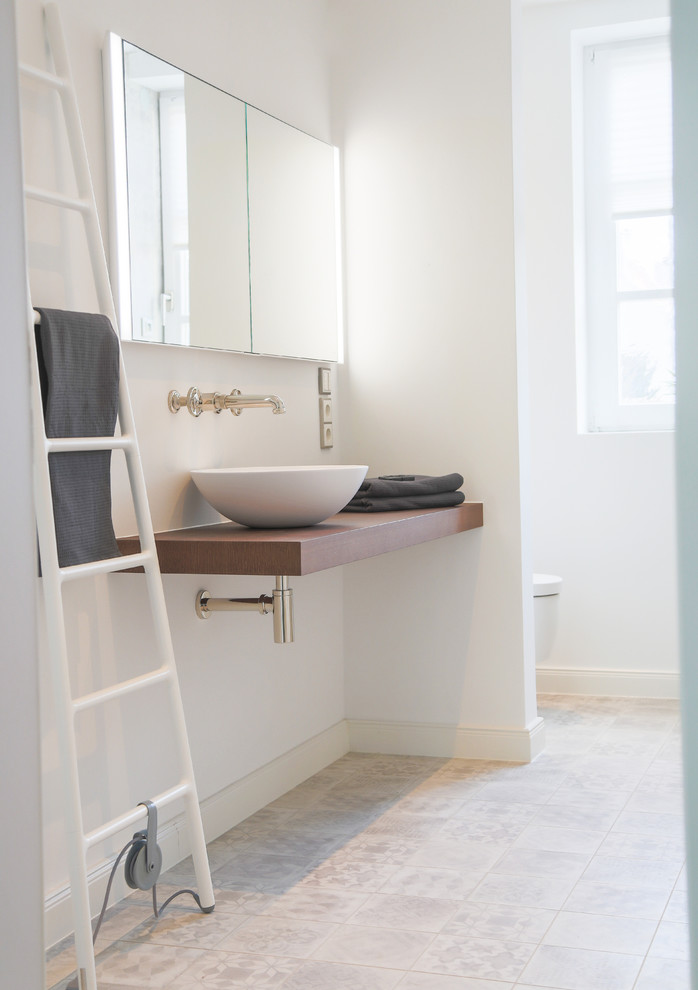 Mittelgroßes Klassisches Duschbad mit dunklen Holzschränken, bodengleicher Dusche, Wandtoilette mit Spülkasten, weißen Fliesen, weißer Wandfarbe, Zementfliesen für Boden, Aufsatzwaschbecken, Mineralwerkstoff-Waschtisch, grauem Boden, offener Dusche und brauner Waschtischplatte in Frankfurt am Main