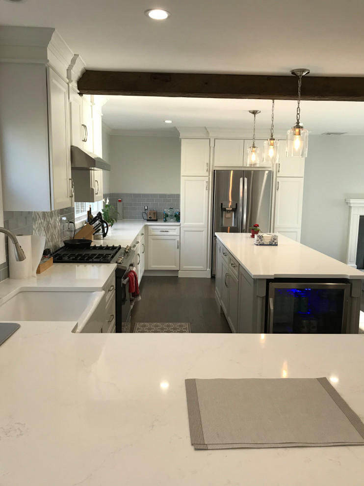 Eat-in kitchen - large transitional u-shaped ceramic tile and gray floor eat-in kitchen idea with a farmhouse sink, recessed-panel cabinets, white cabinets, quartz countertops, gray backsplash, subway tile backsplash, stainless steel appliances, an island and white countertops