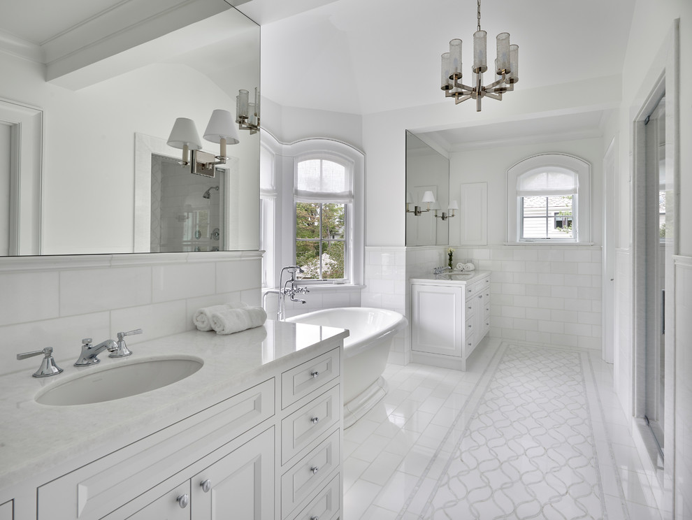 Example of a tuscan master white tile and subway tile marble floor and white floor freestanding bathtub design in Chicago with white cabinets, white walls, a hinged shower door, recessed-panel cabinets, an undermount sink and white countertops