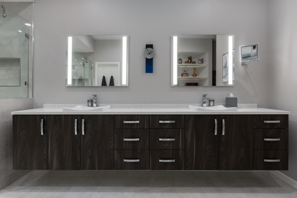 Design ideas for a mid-sized contemporary master bathroom in Tampa with brown cabinets, a double shower, a one-piece toilet, gray tile, ceramic tile, grey walls, a drop-in sink, granite benchtops, a hinged shower door, white benchtops, a shower seat, a double vanity and a floating vanity.