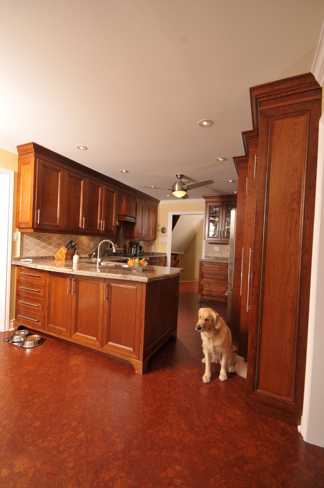 This is an example of a mid-sized traditional u-shaped eat-in kitchen in Toronto with an undermount sink, flat-panel cabinets, medium wood cabinets, granite benchtops, beige splashback, stone tile splashback and stainless steel appliances.