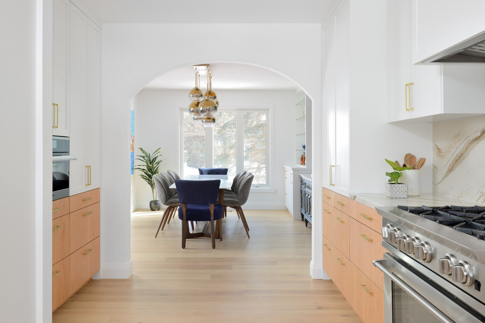 Inspiration for an expansive midcentury l-shaped kitchen/diner in Toronto with a single-bowl sink, shaker cabinets, light wood cabinets, engineered stone countertops, multi-coloured splashback, engineered quartz splashback, stainless steel appliances, light hardwood flooring, an island, brown floors and multicoloured worktops.