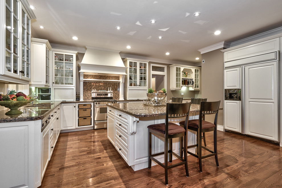 Large transitional u-shaped dark wood floor kitchen photo in Toronto with a double-bowl sink, raised-panel cabinets, white cabinets, granite countertops, paneled appliances and an island