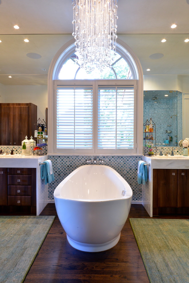This is an example of a traditional bathroom in Dallas with flat-panel cabinets, dark wood cabinets, a freestanding tub and blue tile.