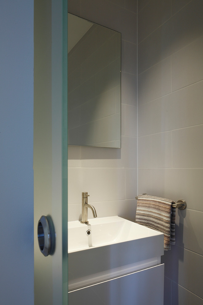 Photo of a contemporary bathroom in London with a wall-mount sink.