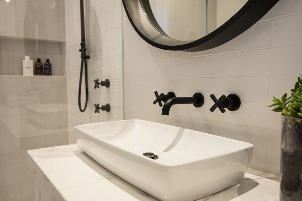 Small contemporary master bathroom in Adelaide with recessed-panel cabinets, white cabinets, a double shower, a wall-mount toilet, white tile, porcelain tile, white walls, porcelain floors, a vessel sink, solid surface benchtops, white floor and a hinged shower door.