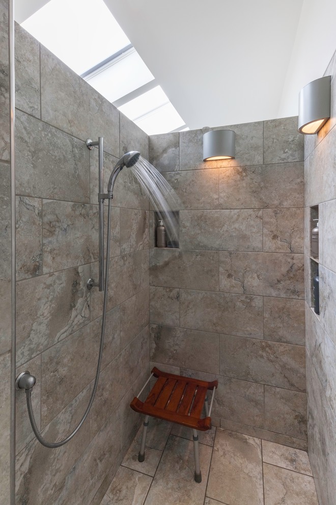 Photo of a mid-sized transitional master wet room bathroom in Portland Maine with flat-panel cabinets, white cabinets, a japanese tub, a one-piece toilet, gray tile, cement tile, white walls, cement tiles, an undermount sink, granite benchtops, grey floor and an open shower.