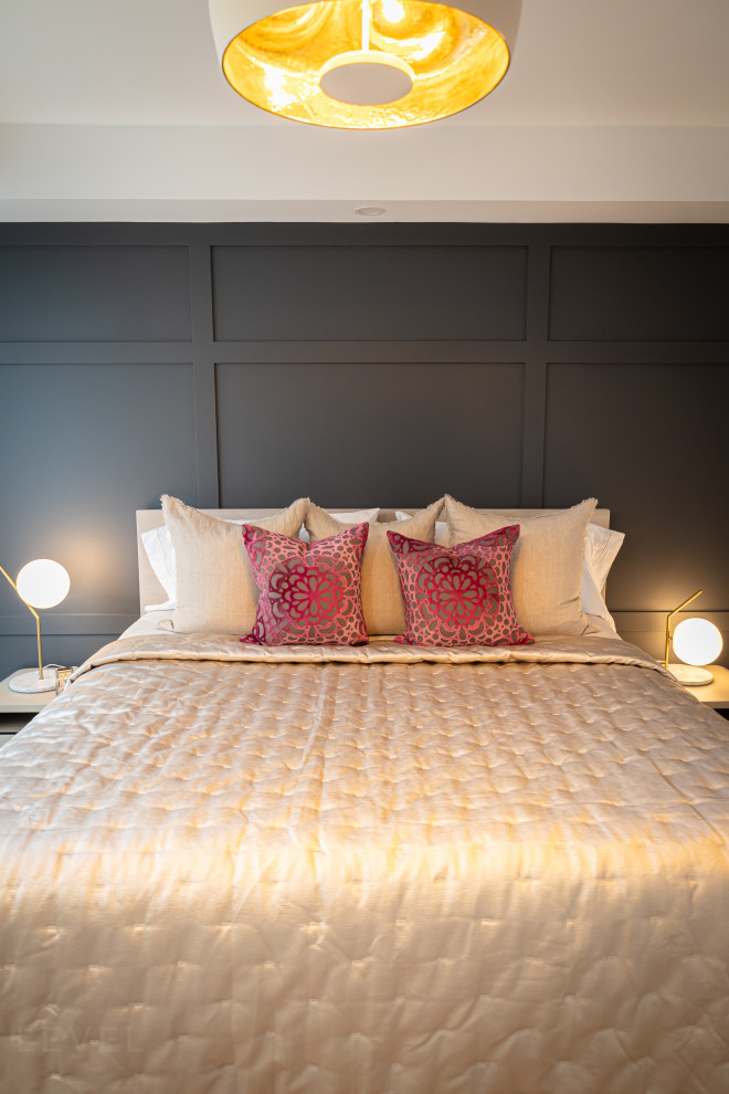 Diseño de dormitorio principal de tamaño medio con paredes azules, suelo de madera clara, suelo marrón y panelado