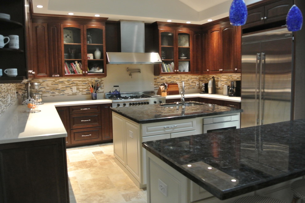 Large transitional u-shaped separate kitchen in San Francisco with an undermount sink, raised-panel cabinets, dark wood cabinets, granite benchtops, multi-coloured splashback, matchstick tile splashback, stainless steel appliances, travertine floors, with island and beige floor.