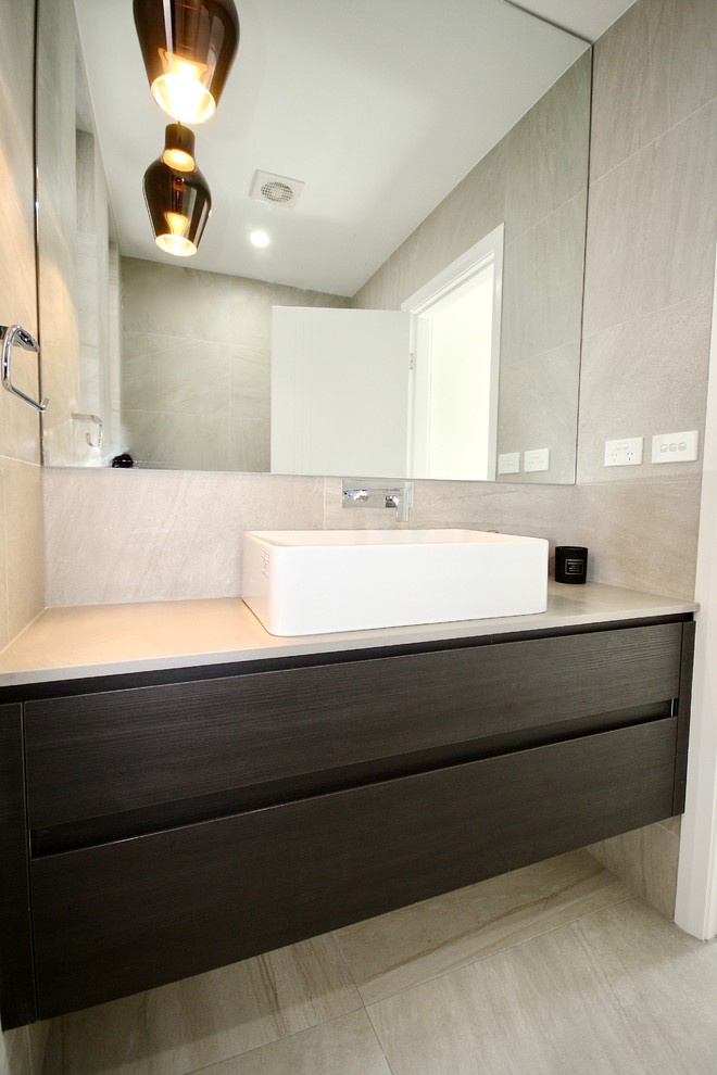 Design ideas for a mid-sized modern 3/4 bathroom in Sydney with flat-panel cabinets, dark wood cabinets, a freestanding tub, an open shower, a two-piece toilet, gray tile, ceramic tile, grey walls, ceramic floors, a vessel sink, engineered quartz benchtops, grey floor and an open shower.