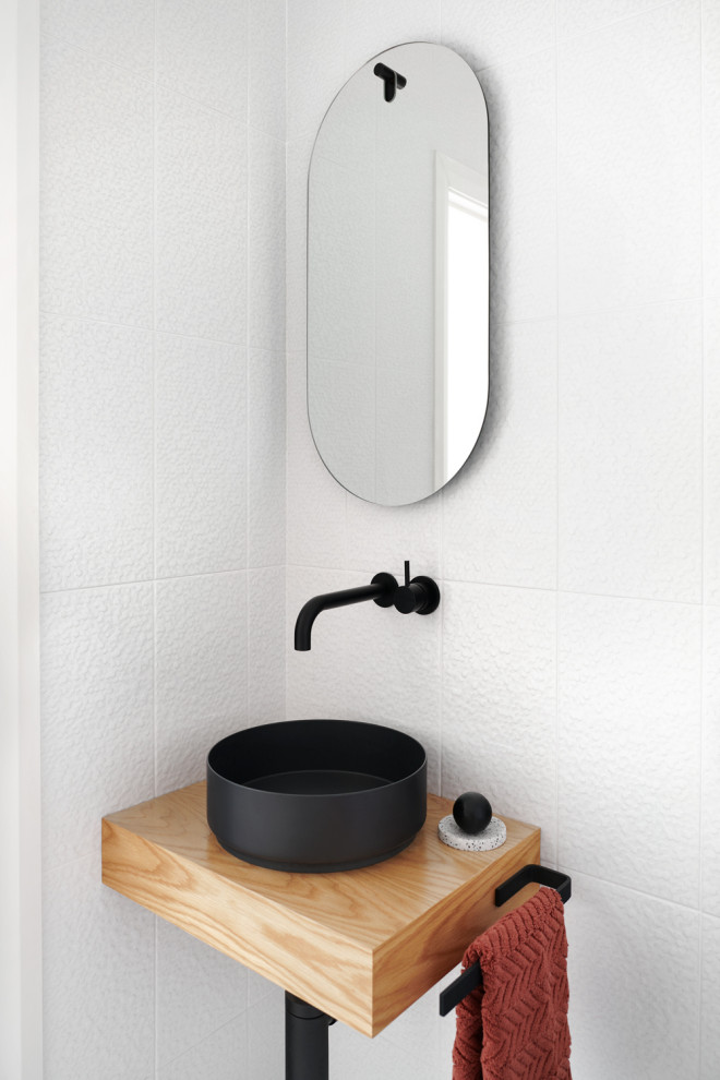 This is an example of a small contemporary powder room in Sydney with white tile, ceramic tile, white walls, a vessel sink and wood benchtops.