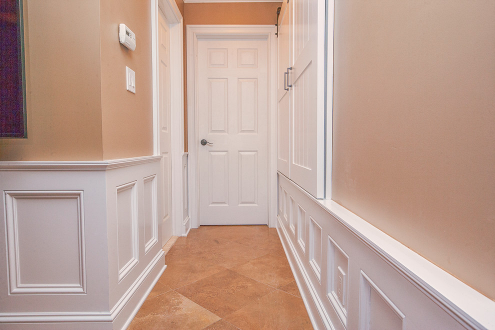 Inspiration for a mid-sized traditional hallway in New York with beige walls, travertine floors and beige floor.